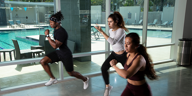 Three students running at the on campus gym